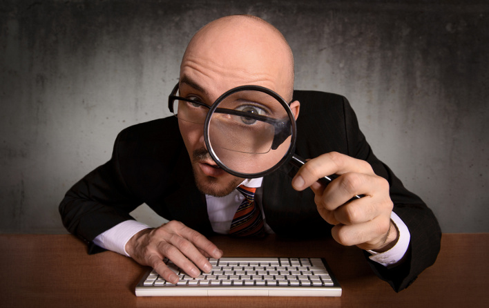 hombre viendo con lupa al lector